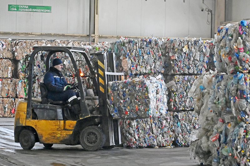 Алексей Гущин на вилочном погрузчике перевозит спрессованный мусор. Фото: Павел Ворожцов
