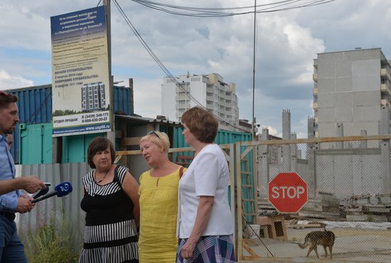 Ольга Ерыкалова (в центре) со своими коллегами  по несчастью показала журналистам замороженную стройку шестнадцатиэтажки. Фото: Александр Зайцев