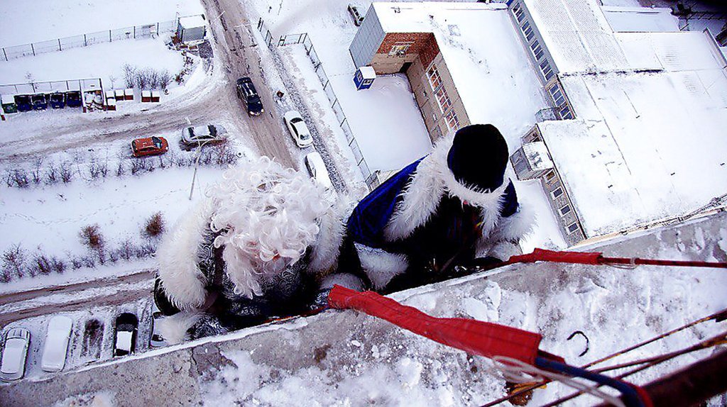 Самое сложное для Деда Мороза-альпиниста — получить доступ на крышу, с которой он будет спускаться. Фото: архив компании «виндоумэн»