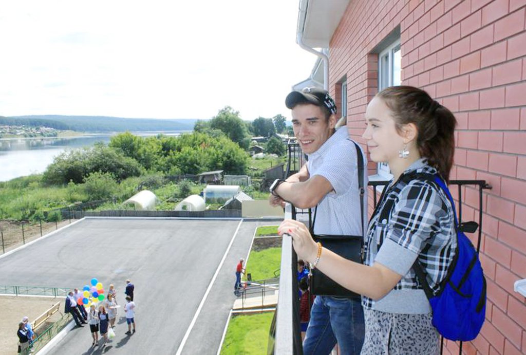 Молодые люди на балконе нового дома