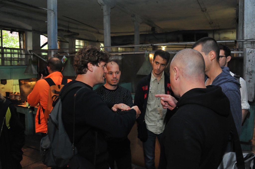 Скульптор Стефан Тиде (на фото слева) в цеху артинского завода объясняет другим художникам, оказавшимся здесь впервые, технологию производства косы. Фото: Александр Зайцев