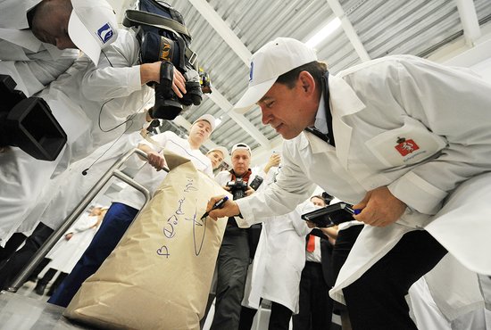 Евгений Куйвашев расписывается на первой упаковке сухого молока, выпущенной в новом цехе в Байкалово. Фото: Владимир Мартьянов