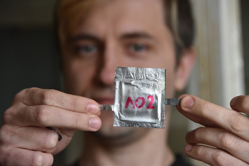 Научный сотрудник Константин Дружинин демонстрирует элемент будущего алюминиево-ионного аккумулятора. Фото: Алексей Кунилов