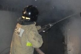 Спасатель тушит пожар в здании