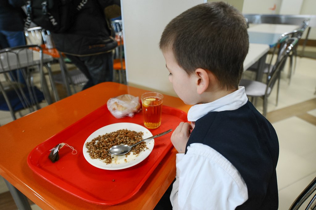 мальчик ест в школьной столовой