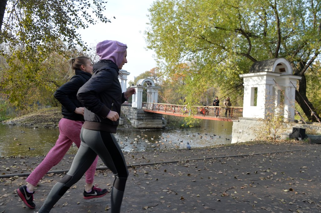 Две девушки бегают в парке