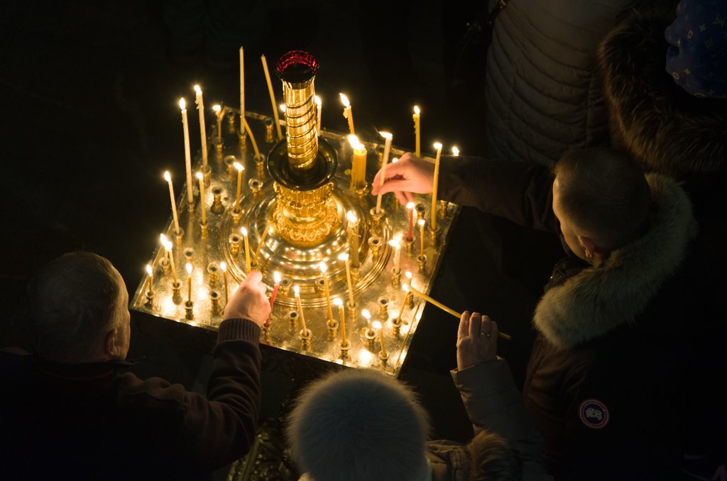 Верующие в храме ставят свечи