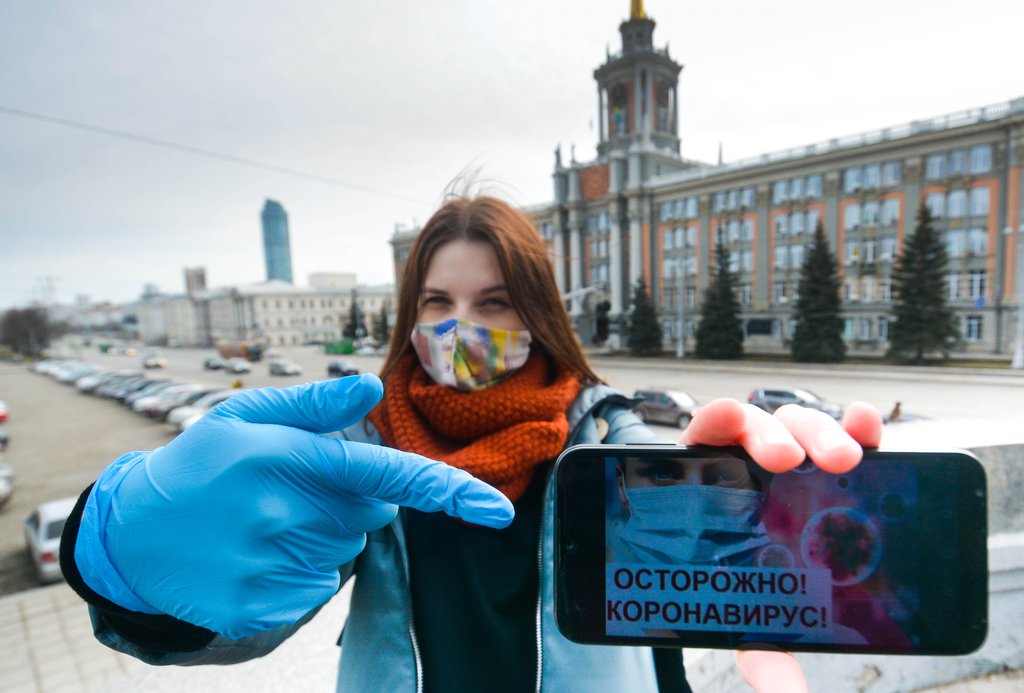 Девушка в маске говорит об опасности коронавируса