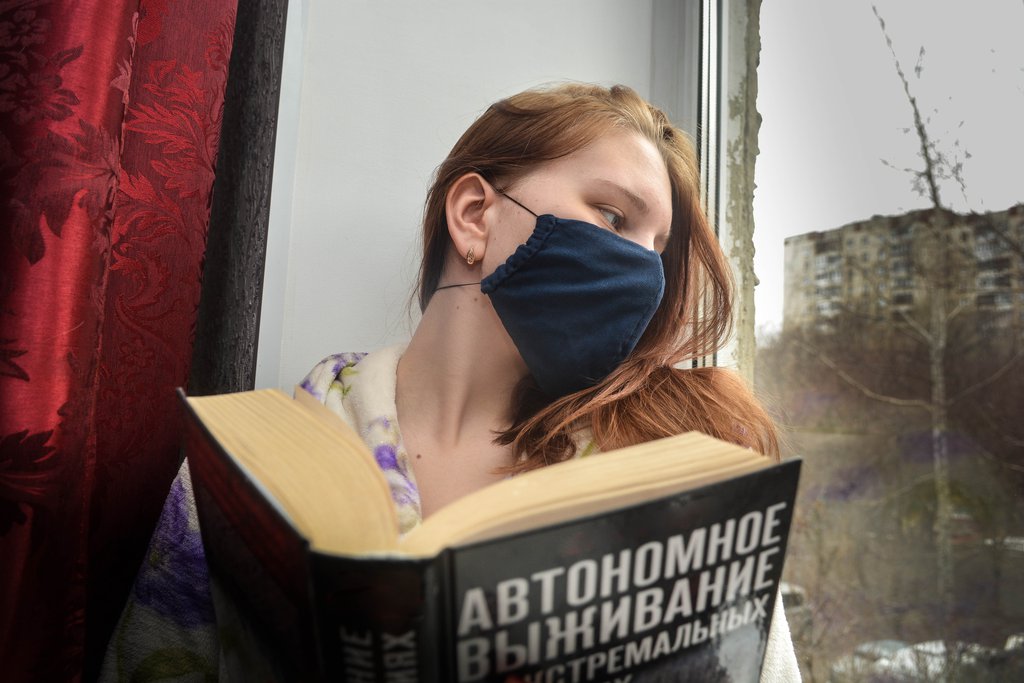 Девушка дома читает на самоизоляции