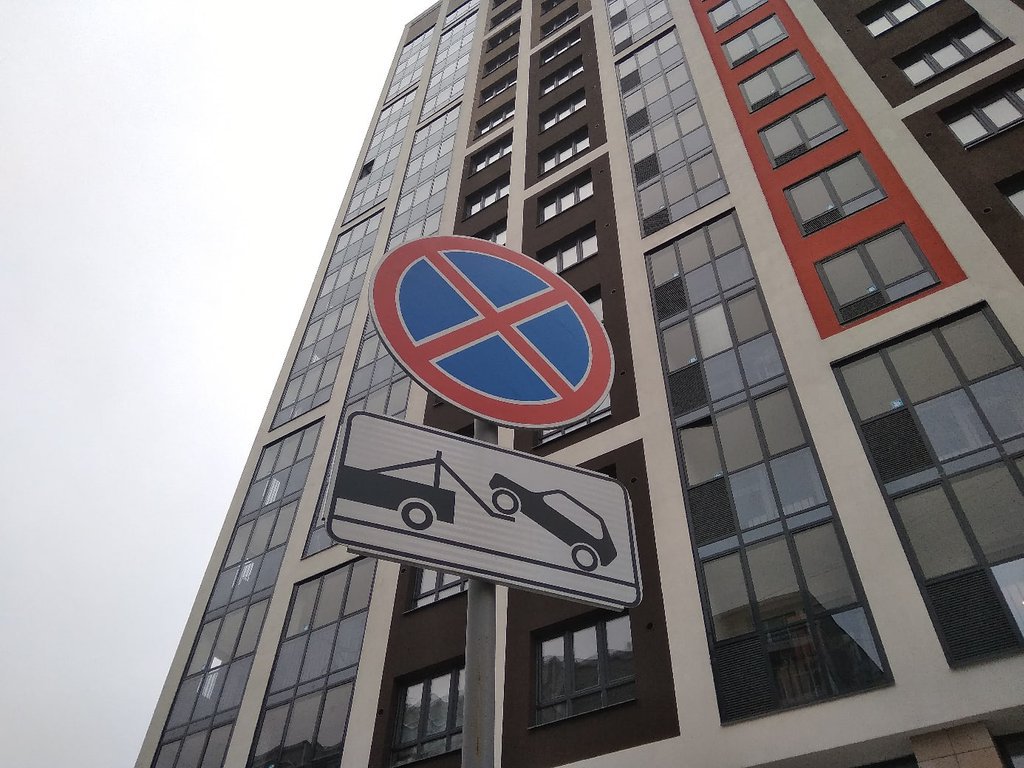 Дорожный знак "Остановка запрещена" у многоэтажки