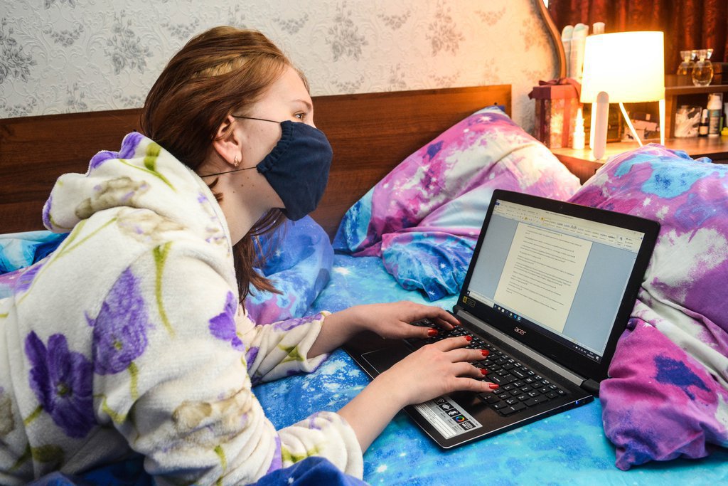 девушка в маске с ноутбуком в кровати