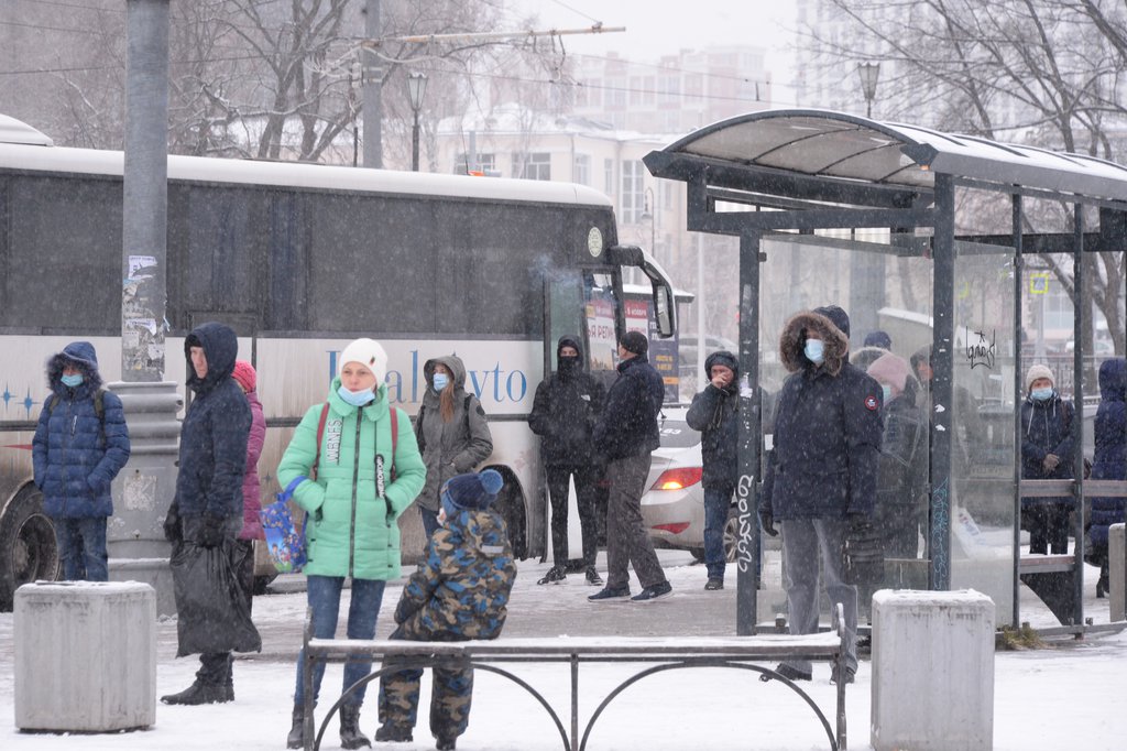 Люди в масках на автобусной остановке