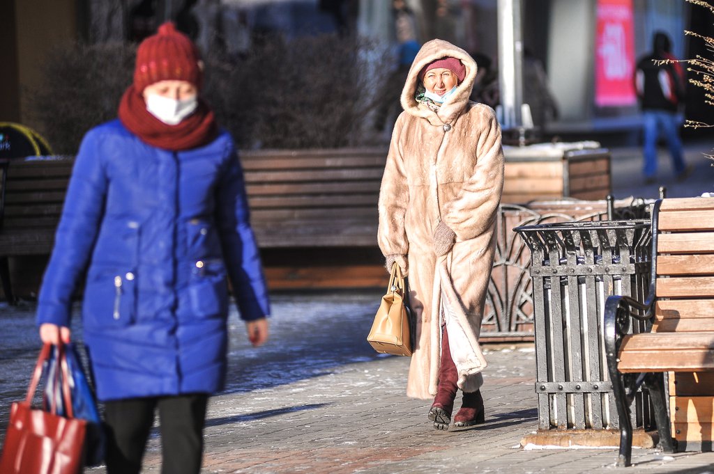 Люди в масках зимой идут по улице