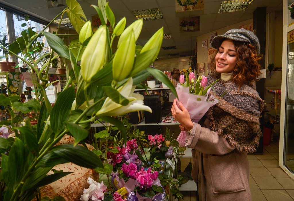 Девушка покупает цветы в цветочном магазине