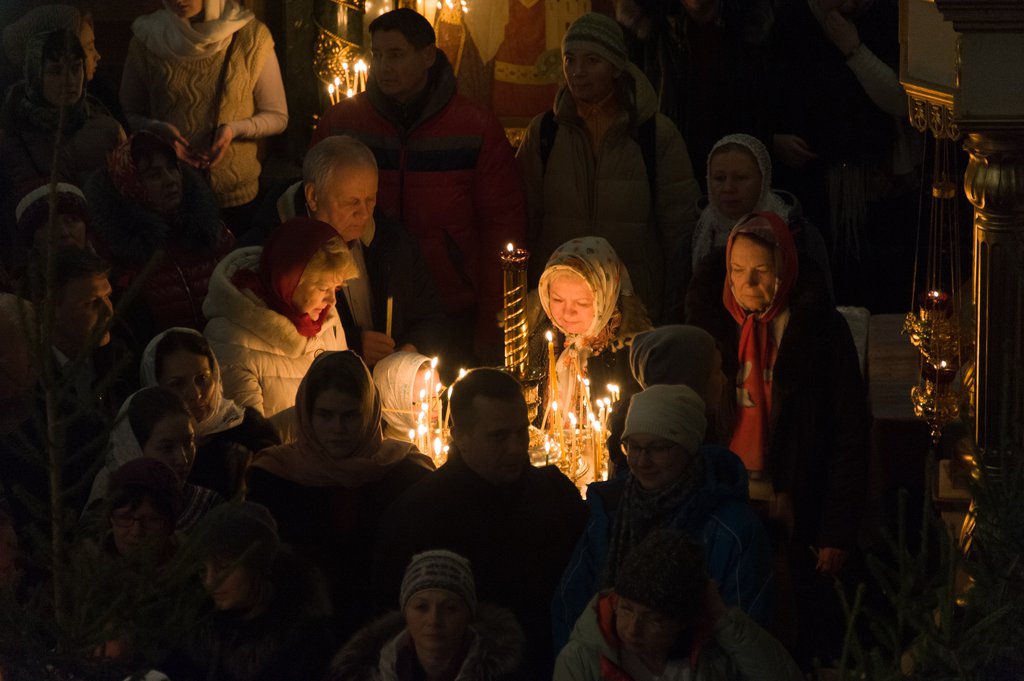 Верующие ставят свечки в храме