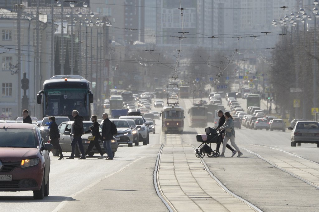 Люди в масках переходят с коляской трамвайные пути