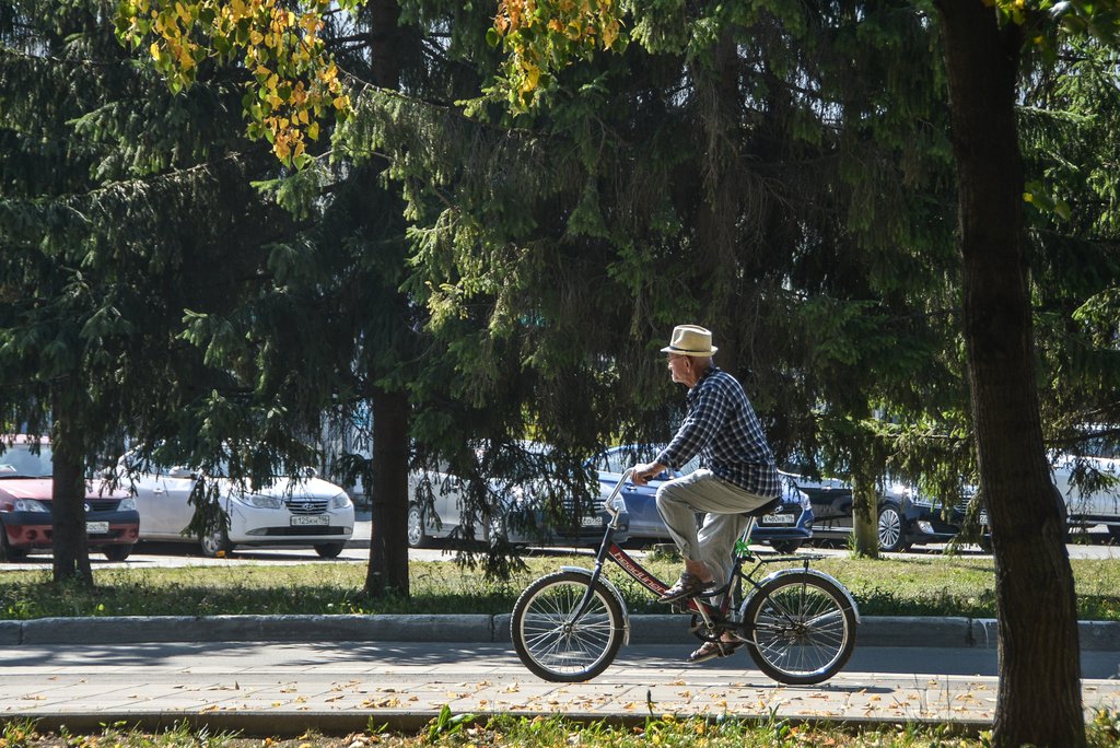 Мужчина в летний солнечный день едет на велосипеде