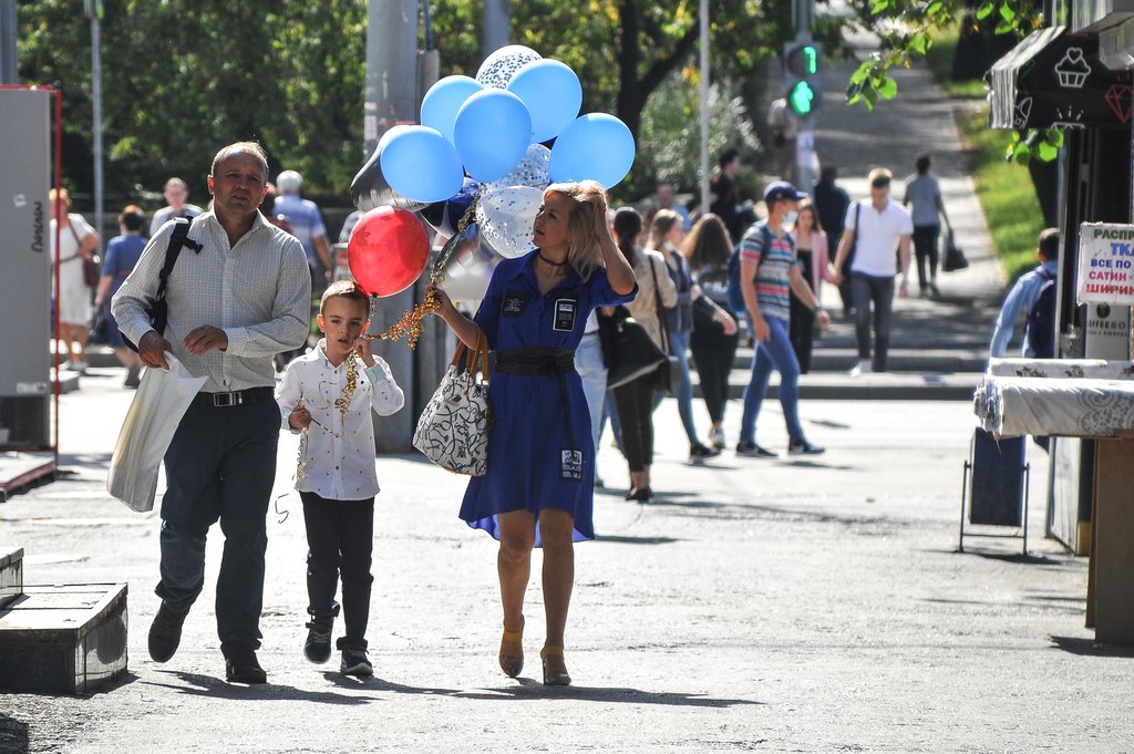 Семья с шариками идёт по улице