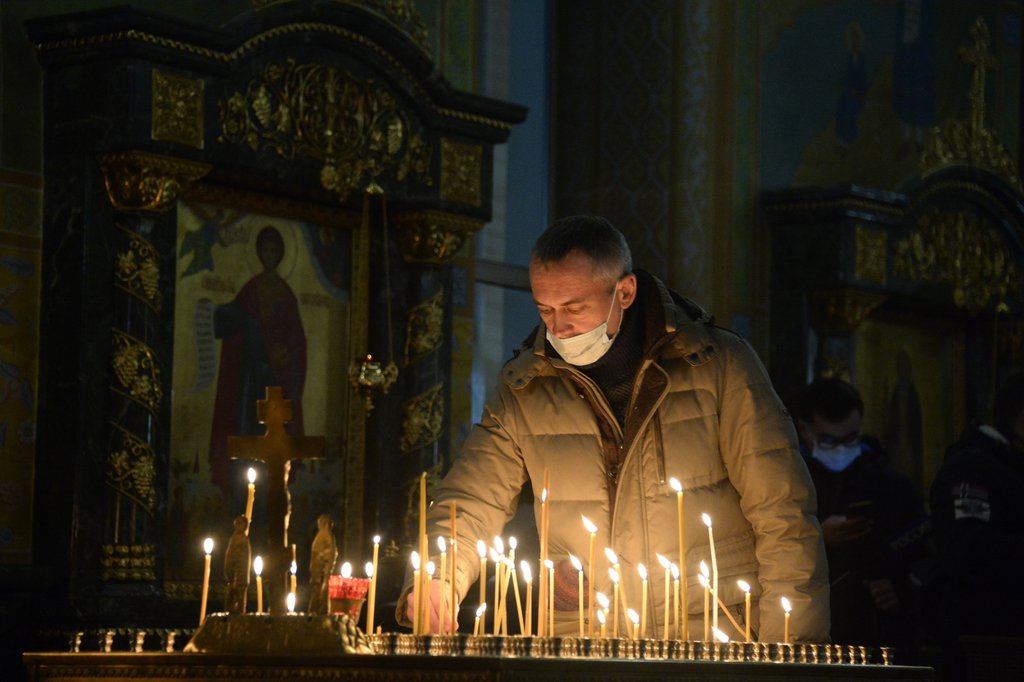 Верующие ставят свечки в храме