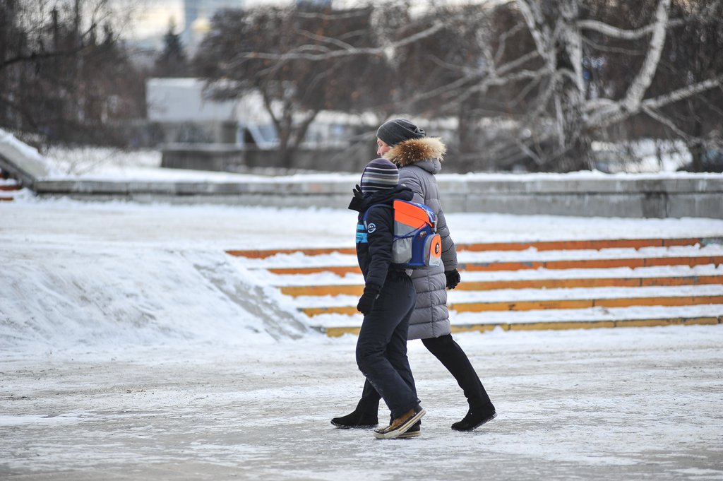 Мама и ребёнок идут по улице зимой