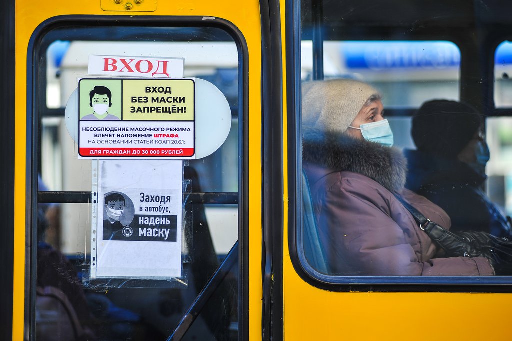 Женщина в маске в автобусе.