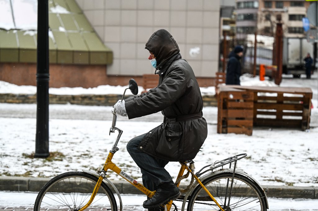 Мужчина едет в маске на велосипеде