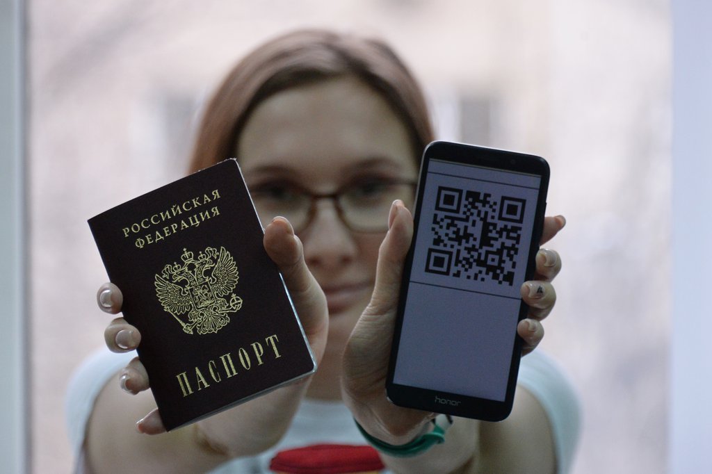 Девушка держит паспорт и куар-код