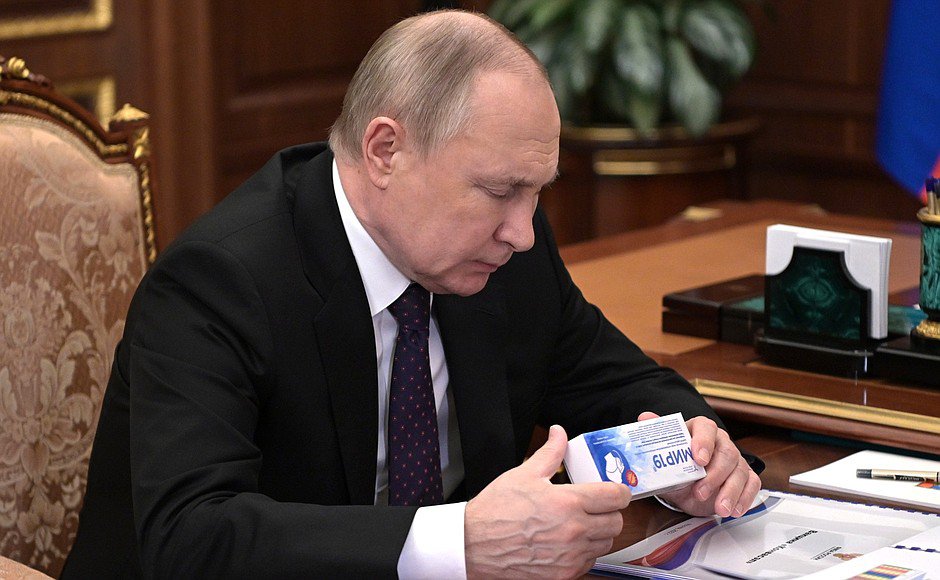 Президент России Владимир Путин держит лекарство в руках