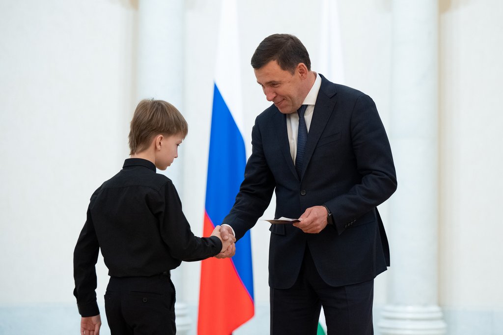 Евгений Куйвашев вручает школьнику паспорт