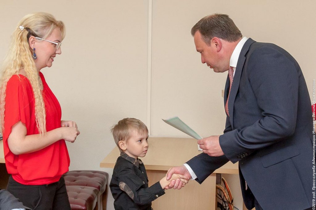 Владислав Пинаев вручает тагильской семье сертификат на получение соцвыплаты