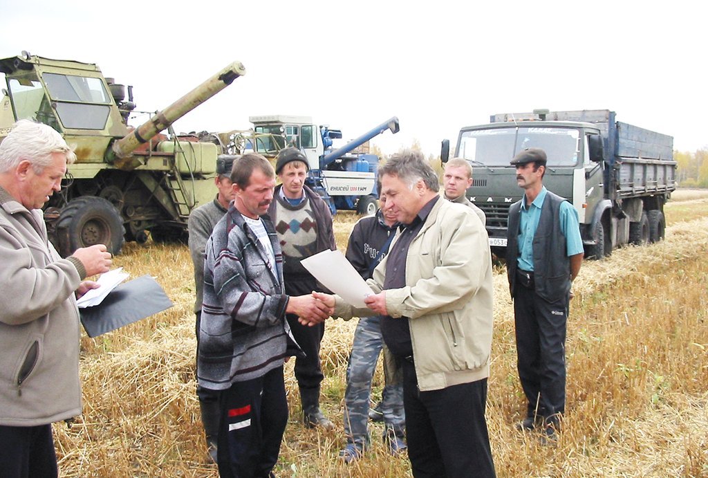 Начальник Слободотуринского управления сельского хозяйства Михаил Жданов вручает комбайнёрам грамоты.
