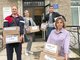 Олеся Салтанова (справа) с коллегами помогает грузить коробки с гуманитарной помощью. Фото: Из личного архива Олеси Салтановой