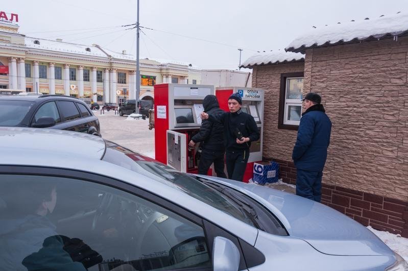 Водители оплачивают стоянку автомобиля в паркомате