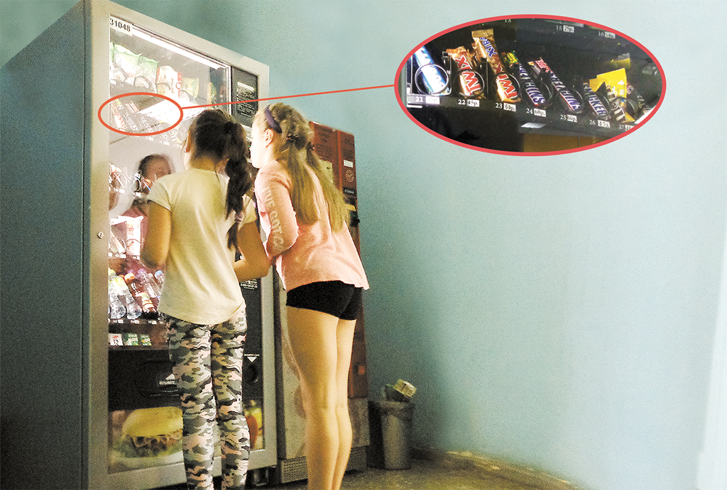 Дети покупают еду в торговом автомате