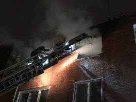 Спасатели тушат из окна загоревшуюся квартиру